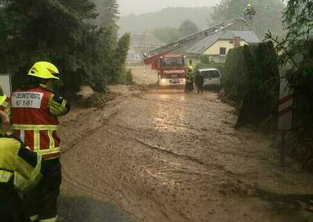 Bei einem Hochwasser ist die Straße überschwemmt, die Feuerwehr Oelsnitz rettet über die Drehleiter eine Familie vom Dach Ihres Hauses da diese durch das Hochwasser eingeschlossen waren.